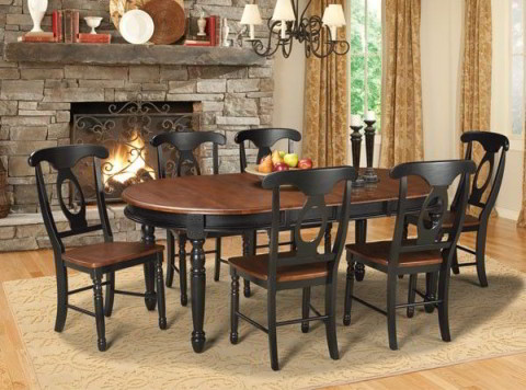 The British Isles Dining Set is a classic take on English country design. This traditional dining room table features an oval, cherry colored table top, with a black base and legs, accompanied by four side chairs.