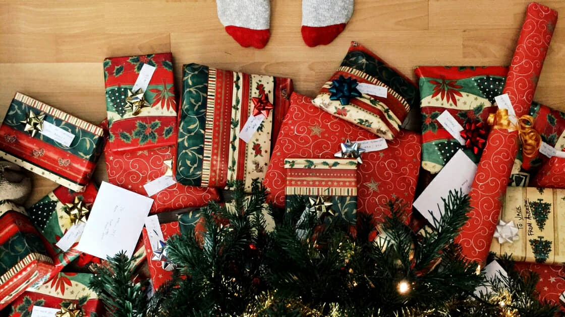 red and green wrapped Christmas gifts underneath Christmas tree